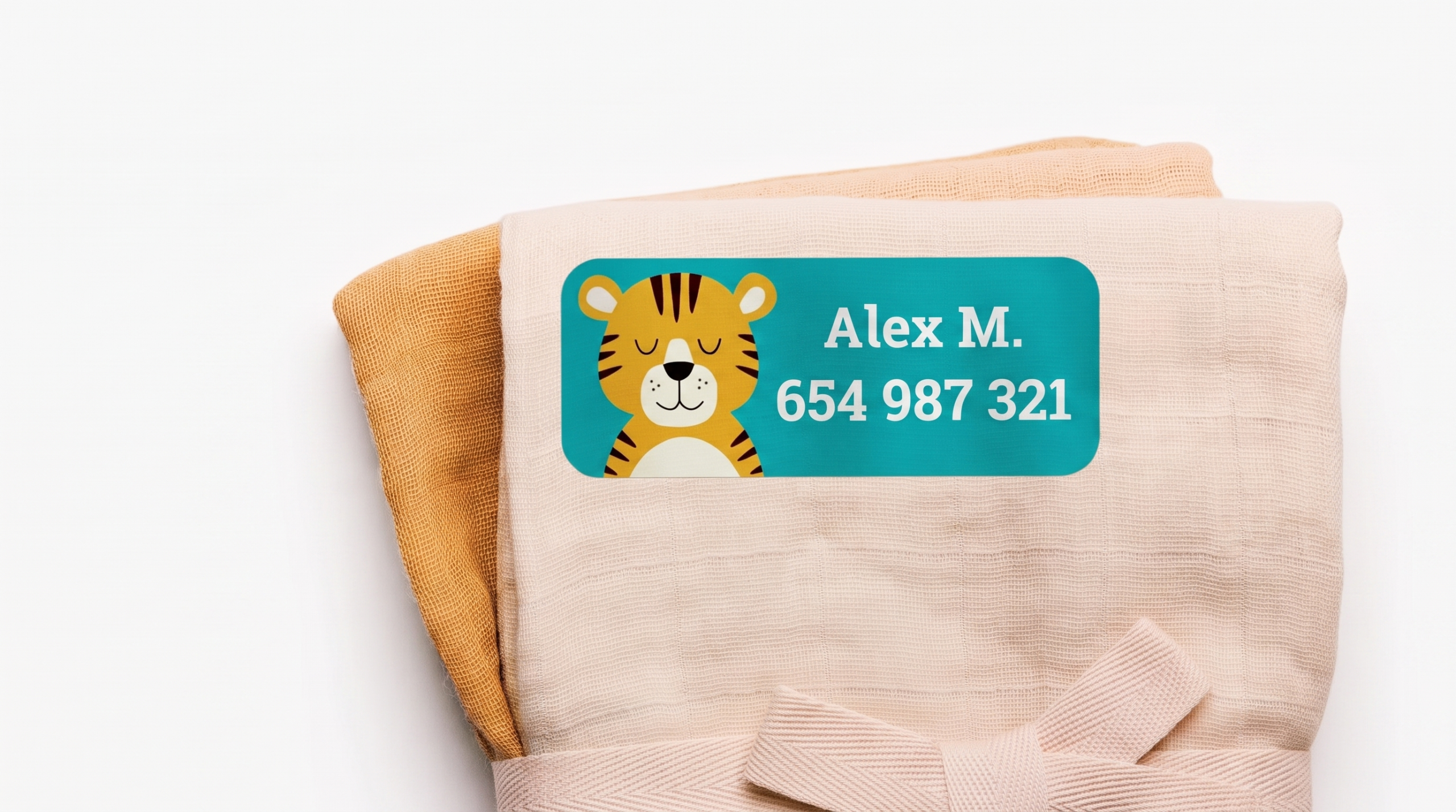 Muselina de bebé marcada con una etiqueta termoadhesiva de nombre con dibujo de tigre