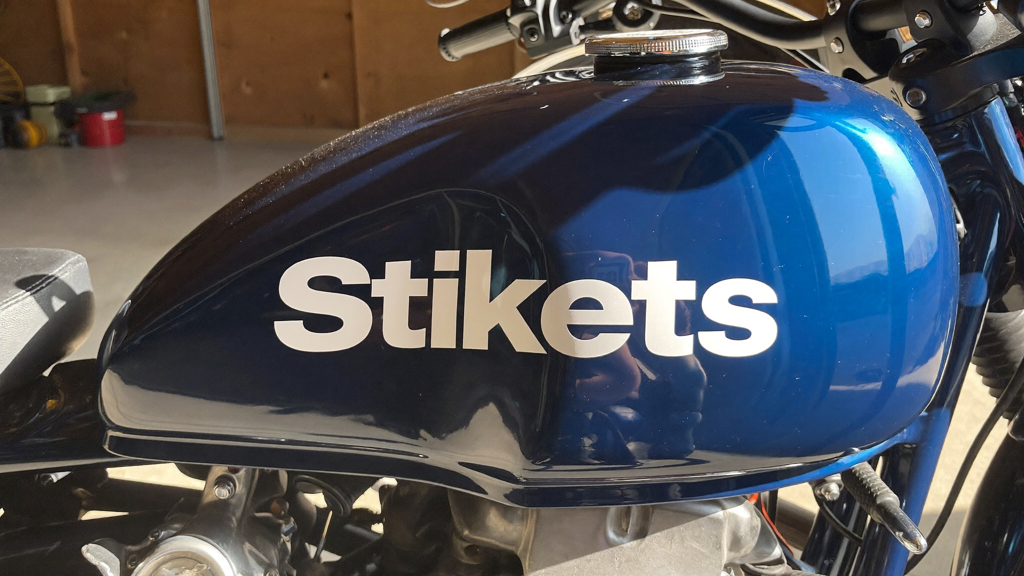 Depósito de moto azul con una pegatina de vinilo blanca personalizada de Stikets