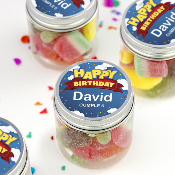 Botes de cristal con chuches de colores y tapa personalizada con el nombre del cumpleañero