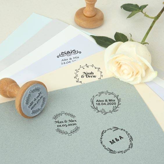 Sello de madera redondo personalizado junto a varias impresiones sobre papel