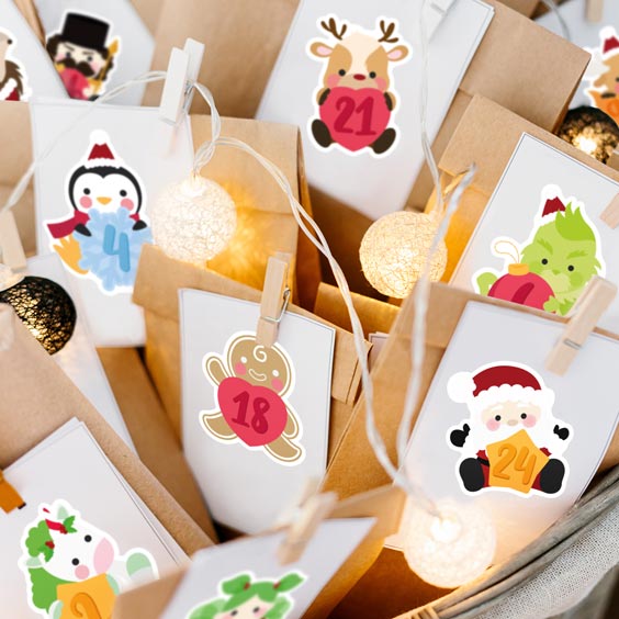 Bolsitas de calendario de Adviento cerradas con pegatinas numeradas de personajes navideños