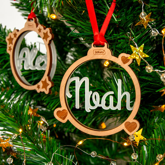 Bola de Navidad con nombre de metacrilato dentro de un marco de madera colgada en el árbol