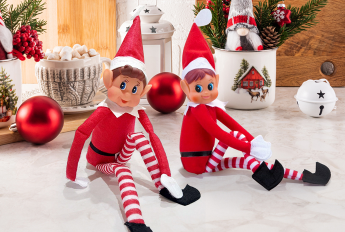 Elfo y elfa navideños traviesos de Stikets sentados juntos sobre una encimera decorada