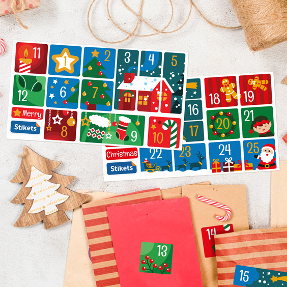 Hojas de pegatinas de calendario de Adviento con paisaje navideño y números del 1 al 25 junto a bolsitas