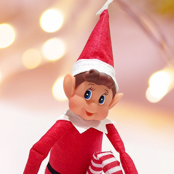 Primer plano del elfo navideño travieso de Stikets con gorro rojo de fieltro y cara sonriente