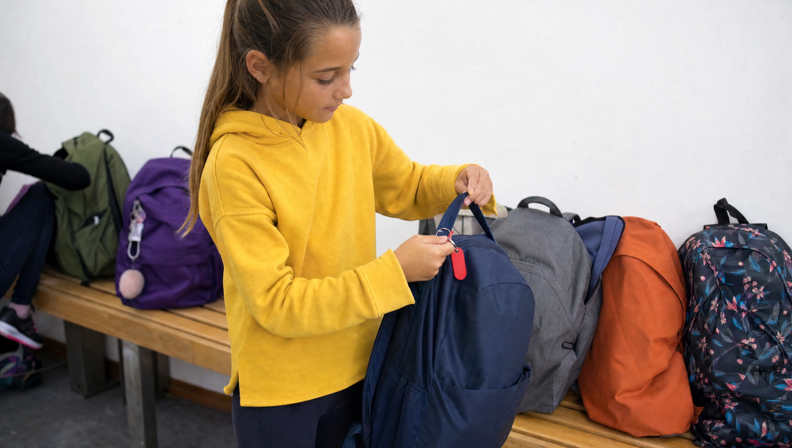 Niña reconociendo su mochila entre otras de distintos colores