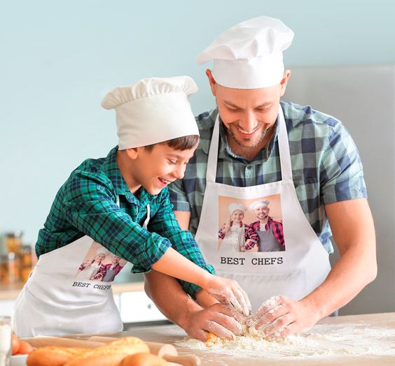 Padre e hijo con delantales personalizados con foto amasando con harina en la cocina