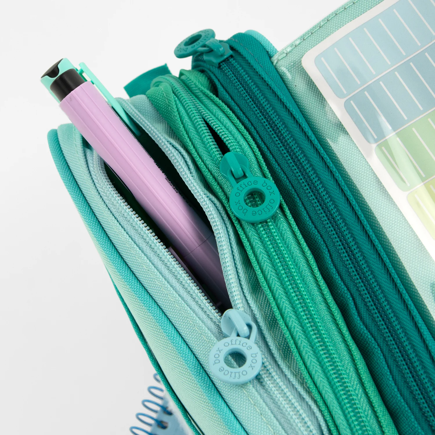 Estuche de tres compartimentos verde con varios útiles en su interior