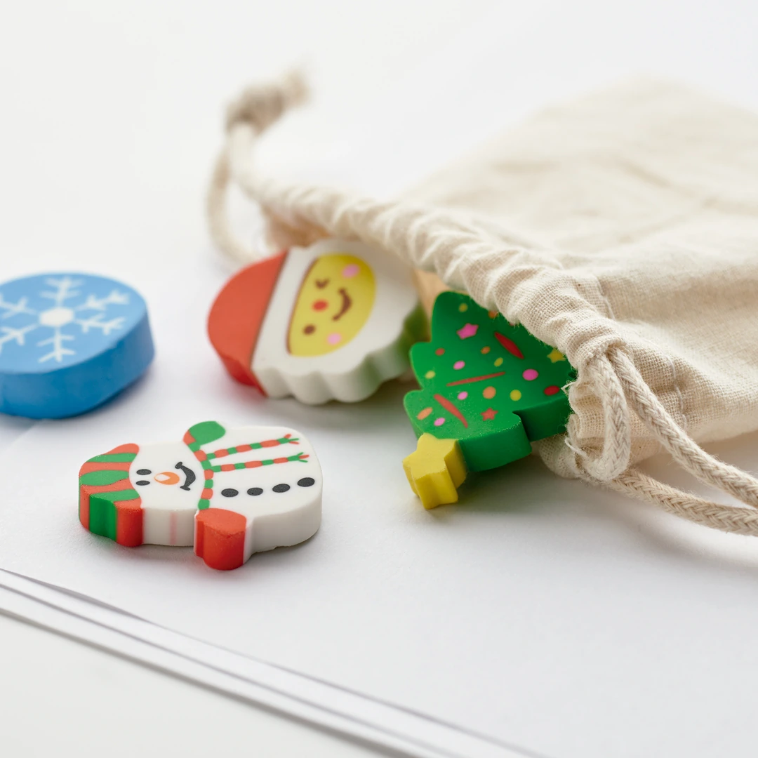 Set de cuatro gomas de borrar navideñas junto a su bolsa de algodón