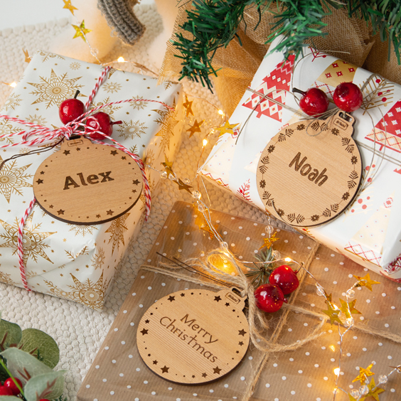 Bolas de Navidad personalizadas de madera grabada con nombre sobre regalos