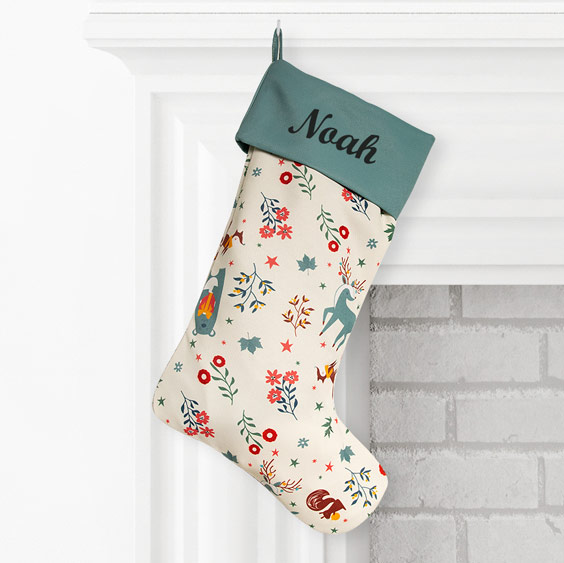 Calcetín navideño de estilo escandinavo con el nombre Noah en el dobladillo, colgado en una chimenea blanca