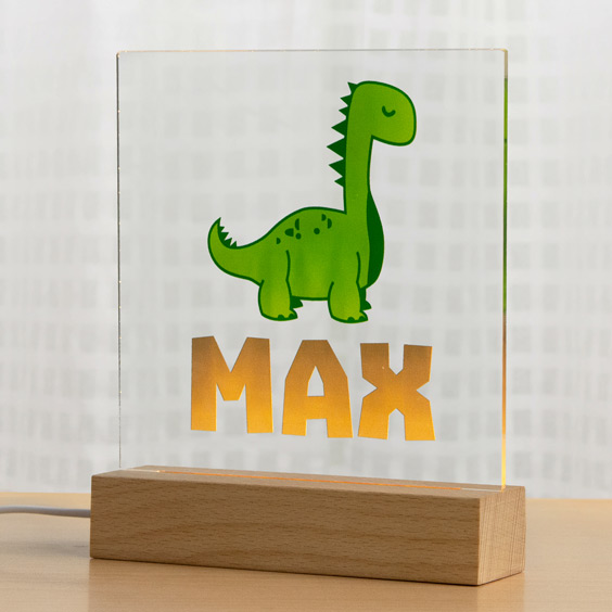 Lámpara LED personalizada Stikets con un dinosaurio y el nombre Max en la placa de metacrilato sobre base de madera