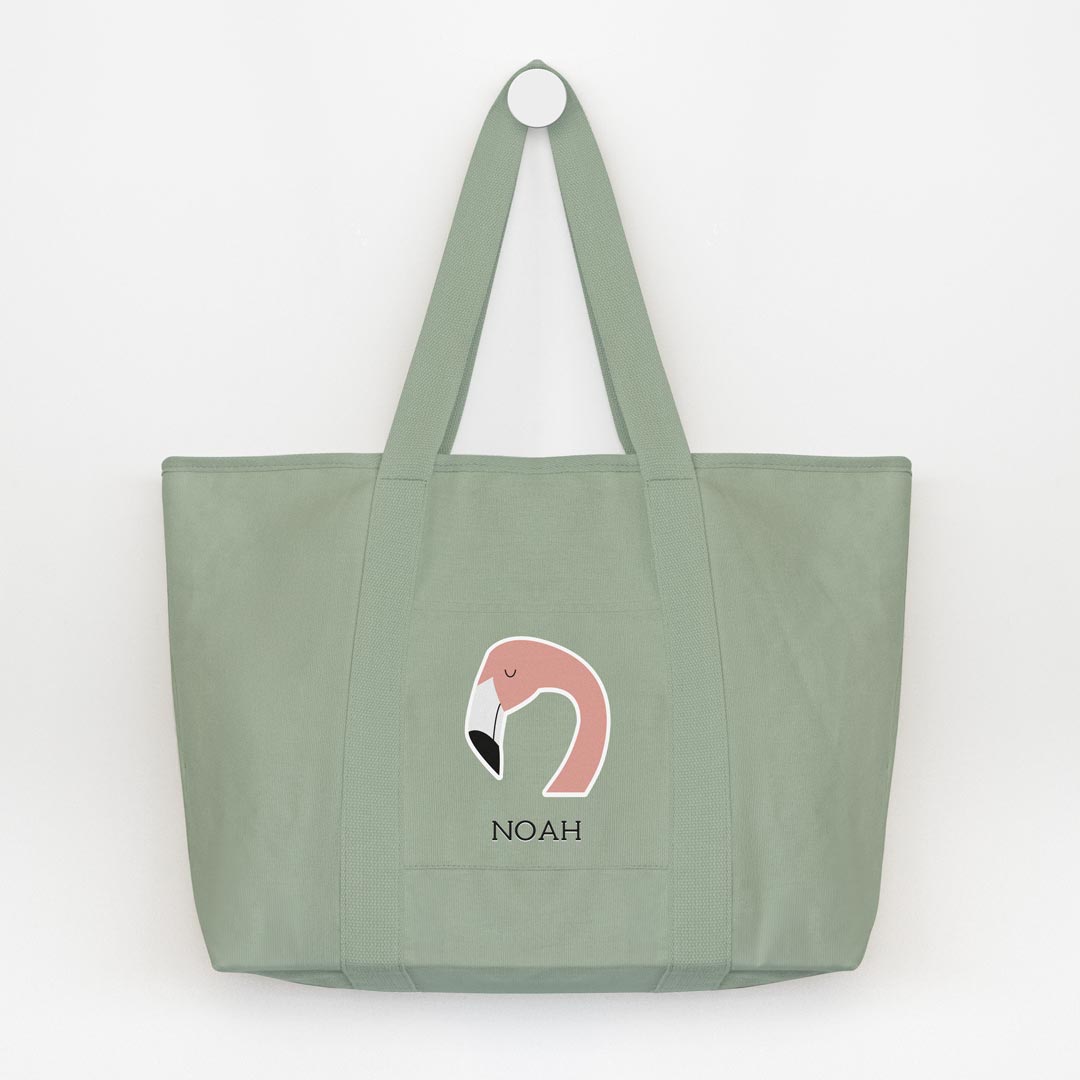 Bolsa totebag grande verde salvia personalizada con icono de flamenco y nombre, colgada de un perchero