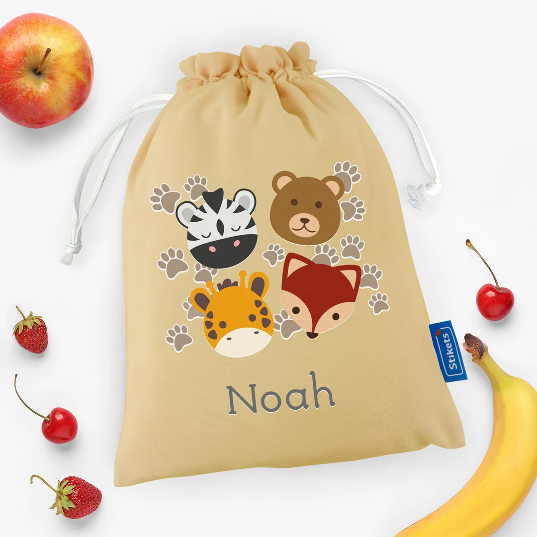 Bolsa de merienda con diseño de animales junto a fruta