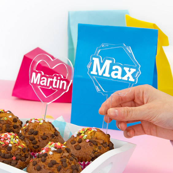 Dos toppers de metacrilato con los nombres Martín y Max sobre cupcakes